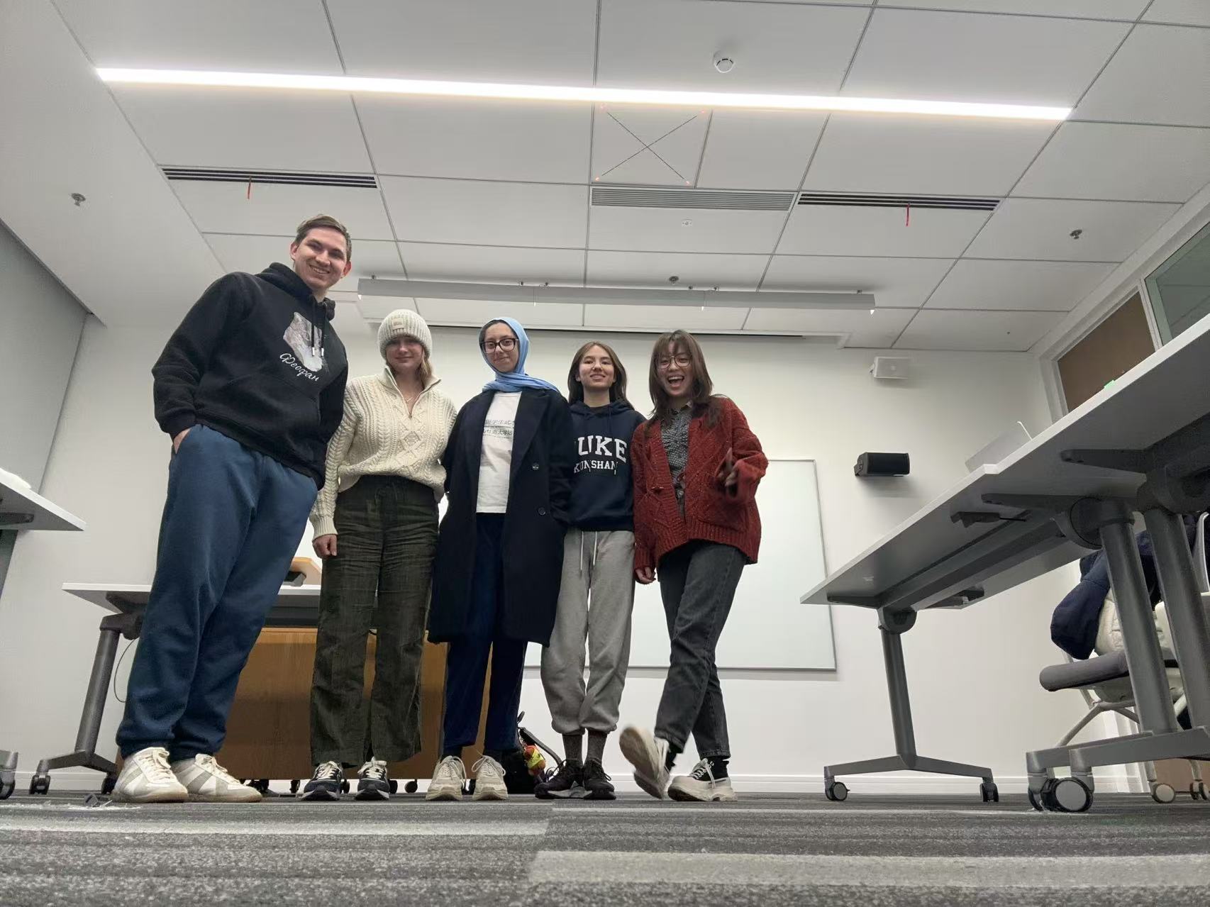 A group of people standing in a room

Description automatically generated