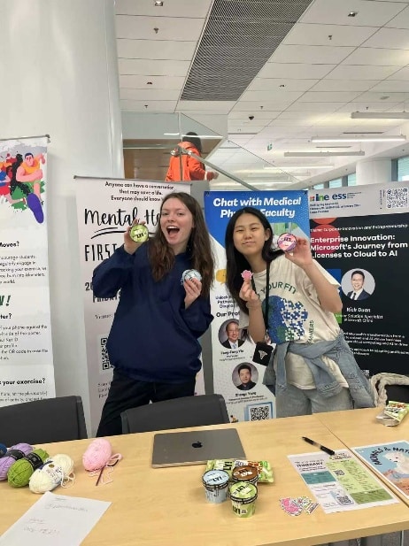 Two women holding small objects

Description automatically generated